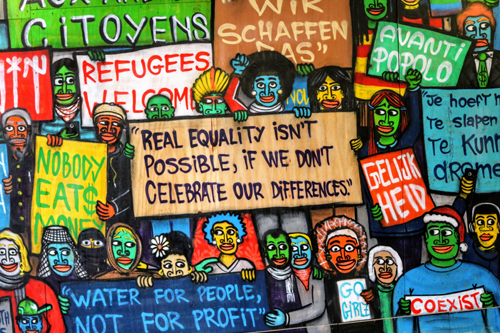 The image shows a human wall with different with different social justice slogans.